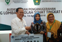 Ketua TP PKK Kabupaten Gresik, Ny. Maria Ulfa Sambari menerima piala dari Dirjen Pendidikan Dasar dan Menengah, Hamid Muhammad.